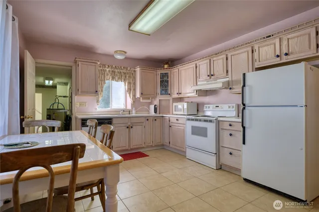 a kitchen with white cabinets and white appliances