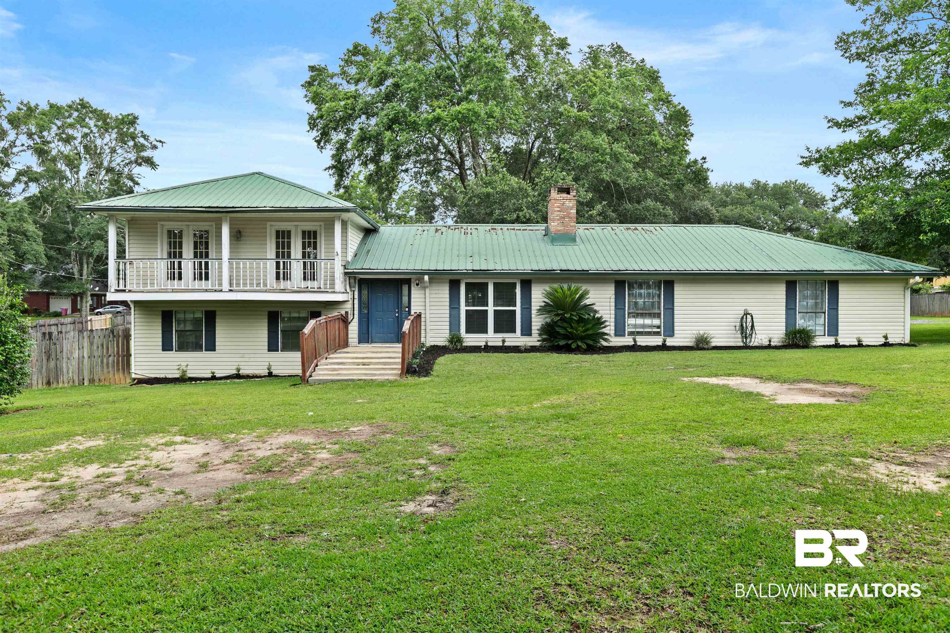 10420 Johnson Road South Mobile, AL 36695 - Photo 7 of 75 Exterior featuring a green metal roof, light-colored siding, and a prominent second-story balcony with white railings