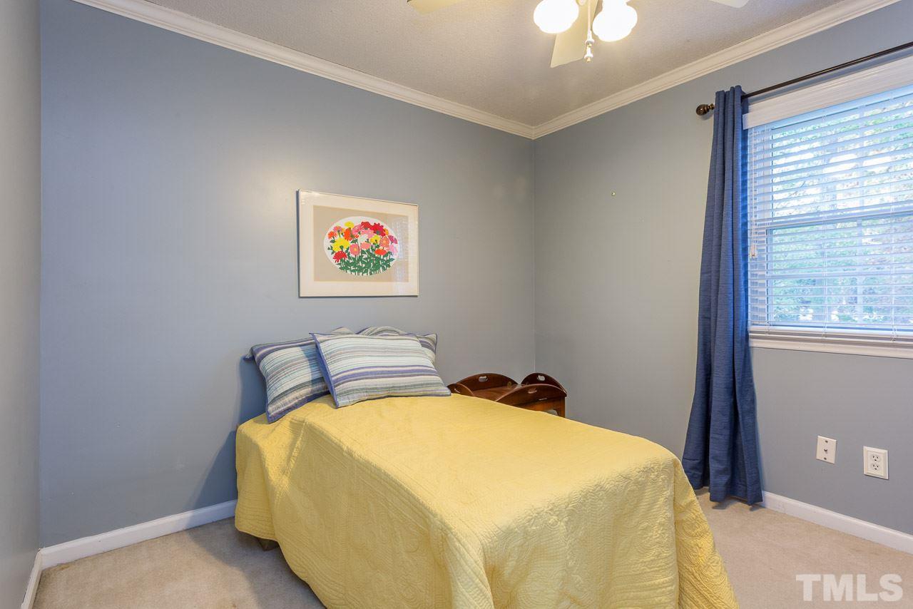 3901 Pin Oak Road Raleigh, NC 27604 - Photo 14 of 24 a bedroom with a bed and a chandelier