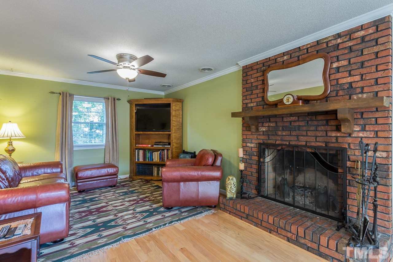 3901 Pin Oak Road Raleigh, NC 27604 - Photo 15 of 24 a living room with furniture a flat screen tv and a fireplace