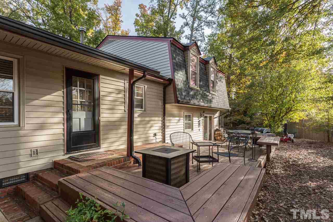 3901 Pin Oak Road Raleigh, NC 27604 - Photo 20 of 24 a view of a patio with table and chairs with wooden fence and floor