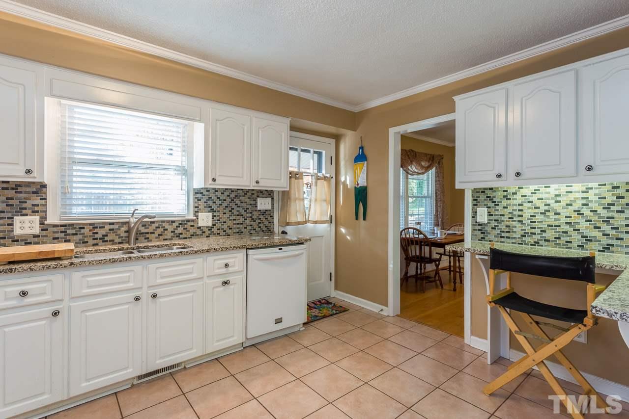 3901 Pin Oak Road Raleigh, NC 27604 - Photo 6 of 24 a kitchen with granite countertop a sink and white cabinets