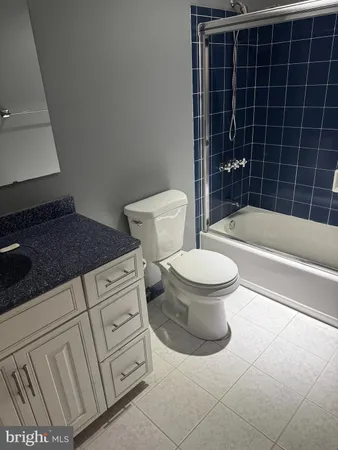a bathroom with a granite countertop toilet and a bathtub