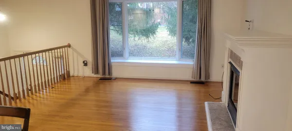 a view of a hallway with wooden floor and a fireplace