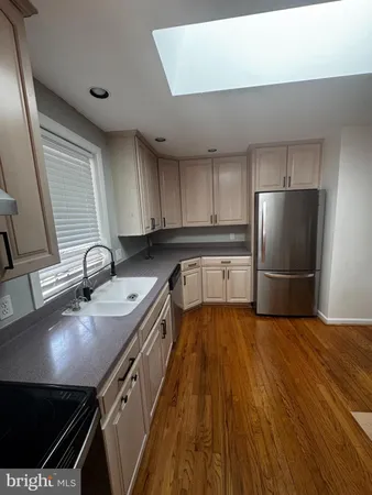 a kitchen with stainless steel appliances granite countertop a sink refrigerator and cabinets