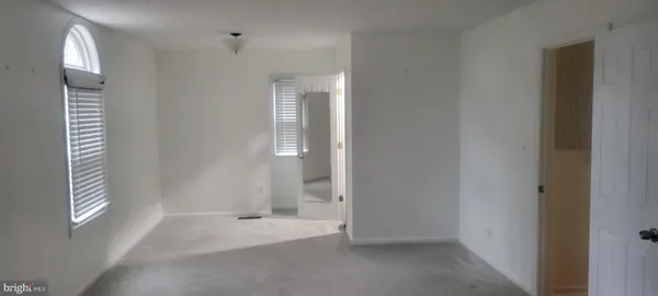 a view of an empty room with windows and closet