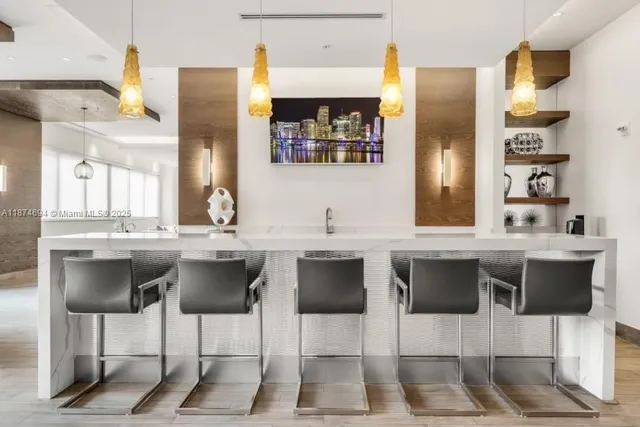 a kitchen with a sink and chairs