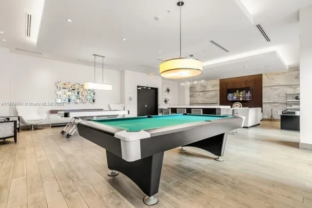 a room with pool table and windows
