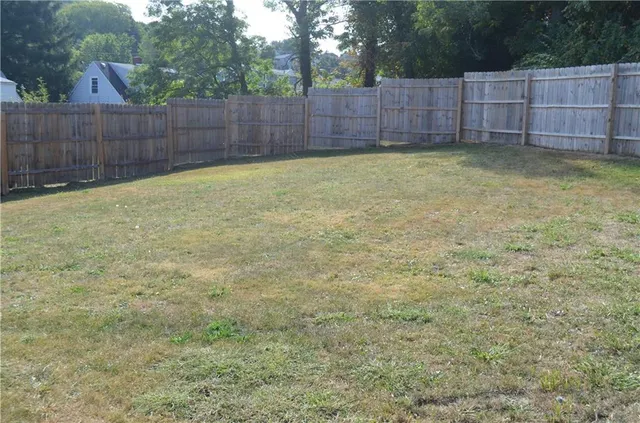 a view of a backyard with wooden fence
