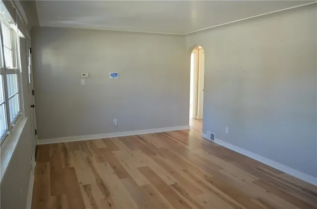 an empty room with wooden floor and a window