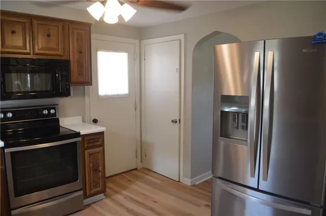 a kitchen with stainless steel appliances granite countertop a refrigerator and a stove top oven