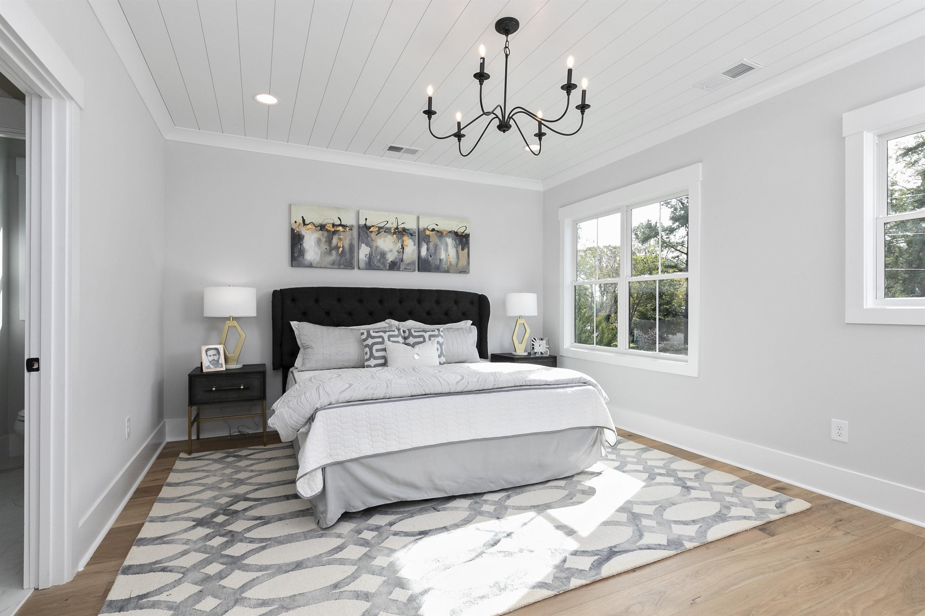 114 Summit Avenue Raleigh, NC 27603 - Photo 27 of 62 a spacious bedroom with a large bed and a chandelier