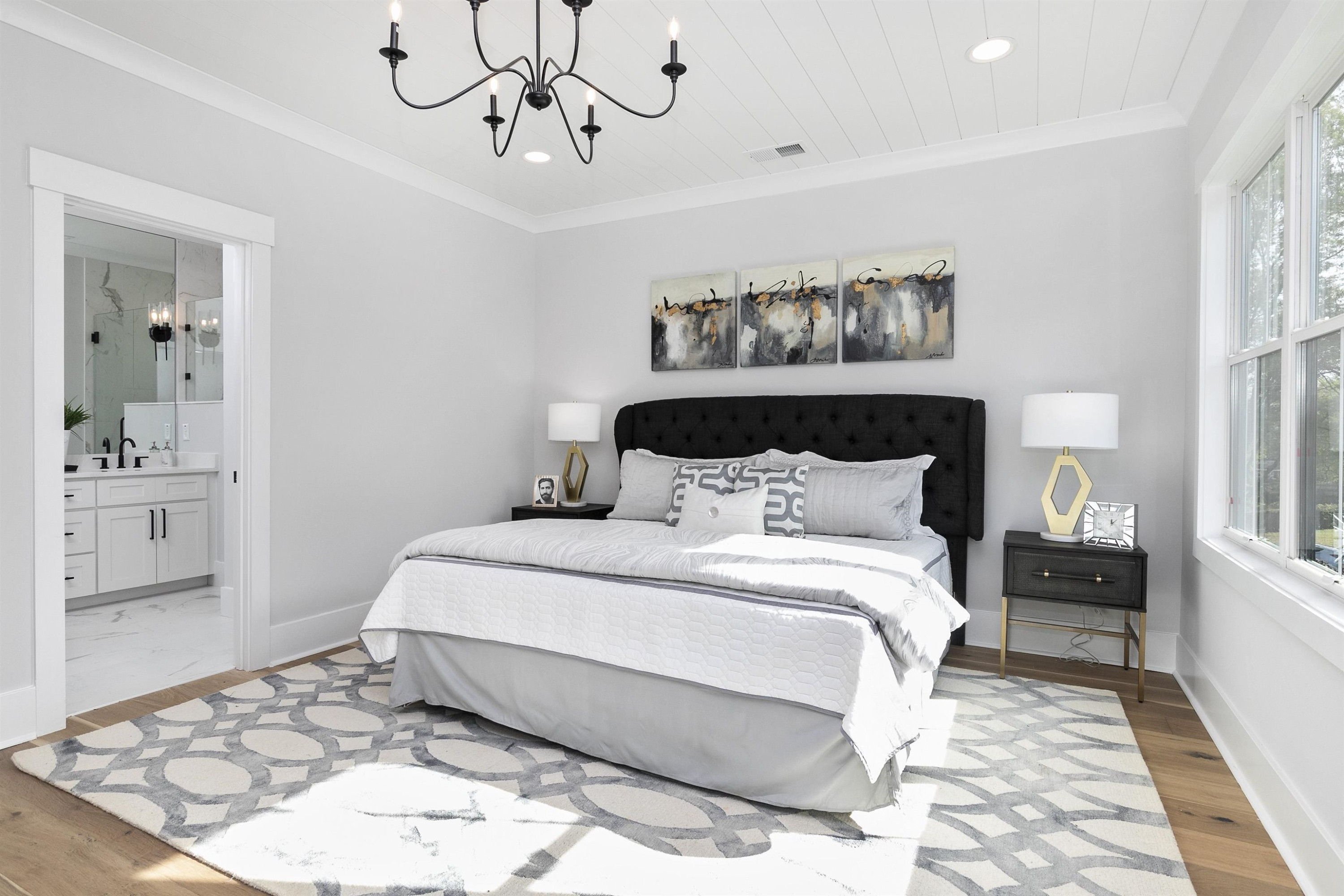114 Summit Avenue Raleigh, NC 27603 - Photo 28 of 62 a bedroom with a large bed and a chandelier