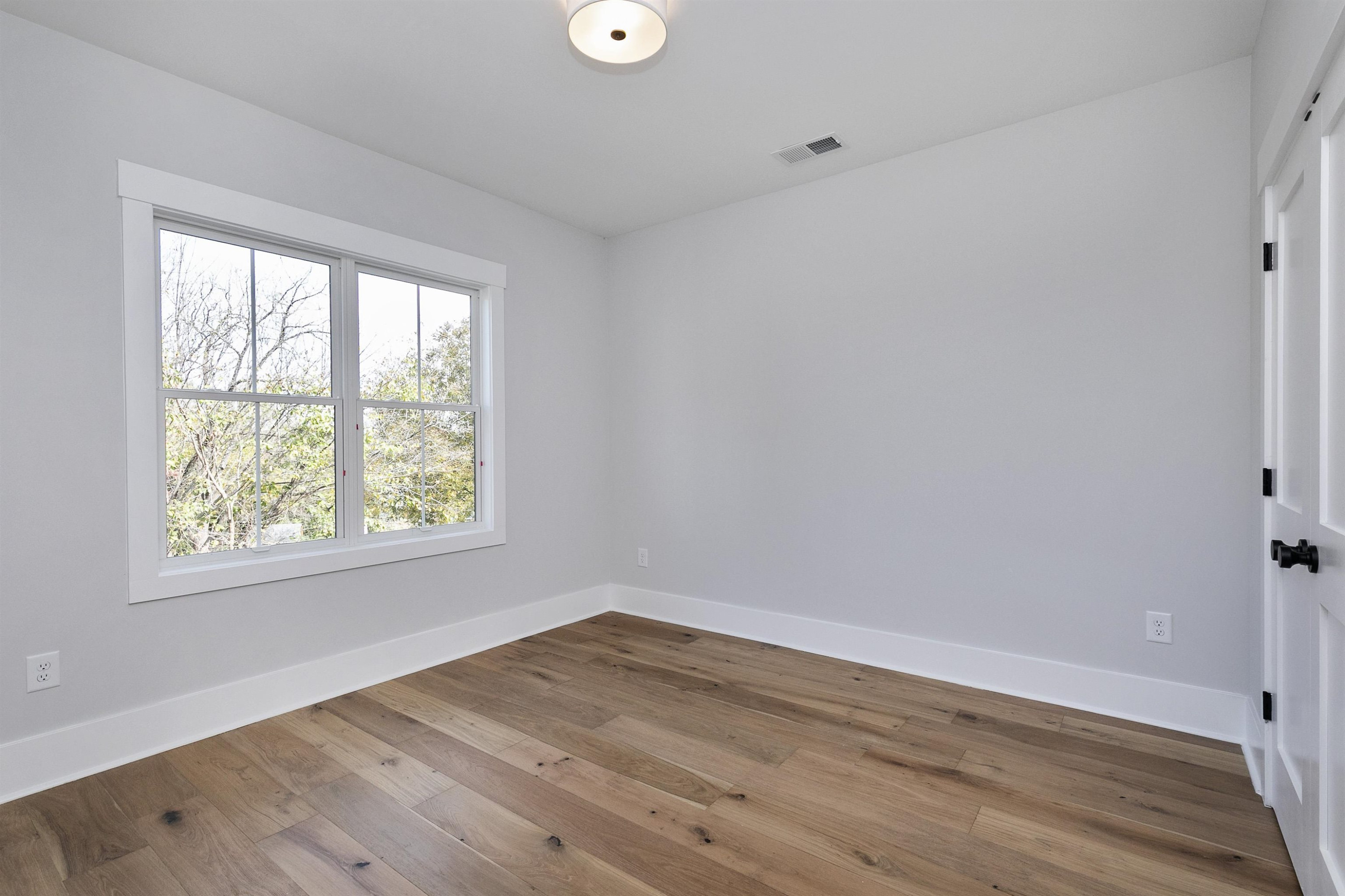 114 Summit Avenue Raleigh, NC 27603 - Photo 33 of 62 an empty room with wooden floor and windows