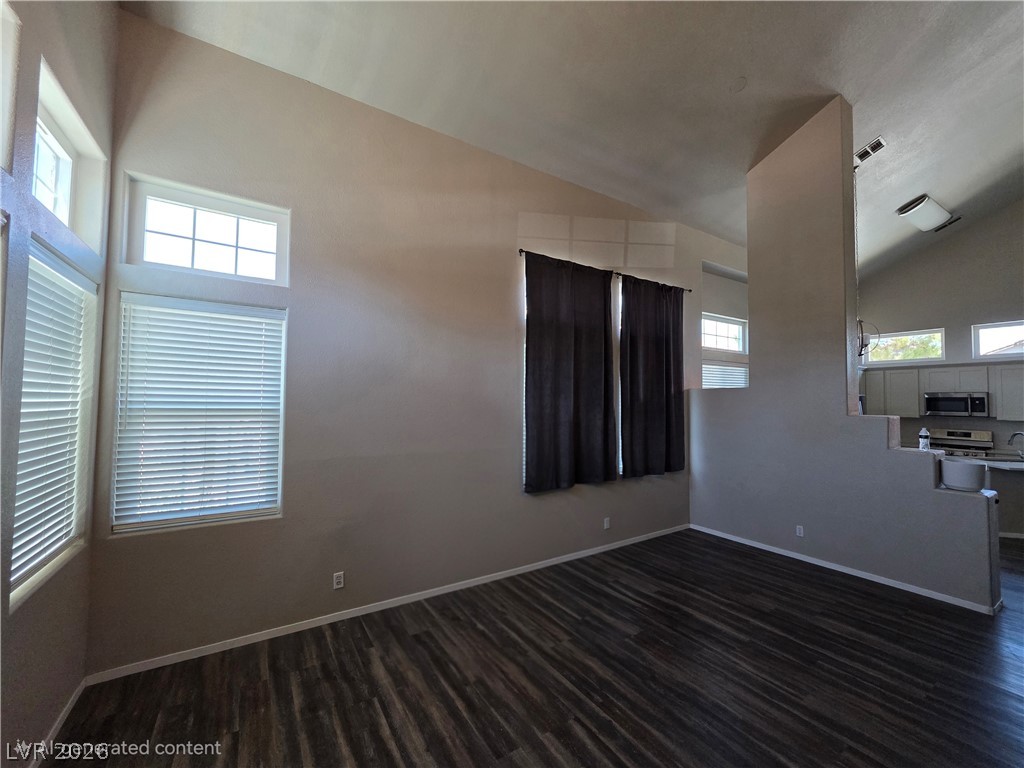 2275 Ramsgate Drive Henderson, NV 89074 - Photo 20 of 84 Well-lit living area with vaulted ceilings and rich wood-style flooring.