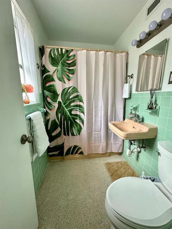 3232 Northeast 15th Street Pompano Beach, FL 33062 - Photo 12 of 16 a bathroom with a toilet a sink and a mirror