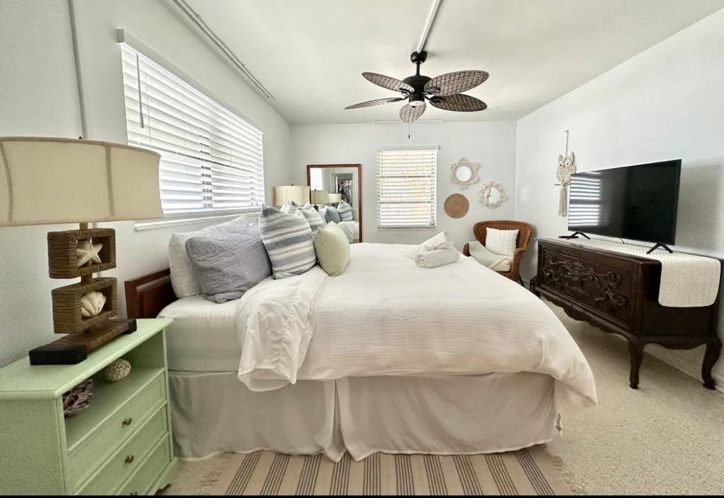 3232 Northeast 15th Street Pompano Beach, FL 33062 - Photo 8 of 16 a bedroom with a bed and a flat tv screen on dresser