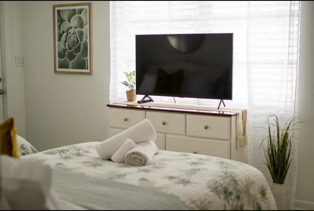 3232 Northeast 15th Street Pompano Beach, FL 33062 - Photo 9 of 16 a bedroom with a bed and flat screen tv