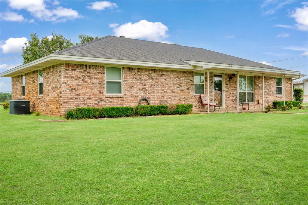 1355 County Road 33100 Sumner, TX 75486 - Photo 16 of 34 View of front of property featuring central air condition unit, a front yard, brick siding, and roof with shingles