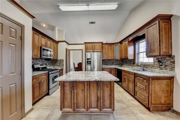 a kitchen with stainless steel appliances granite countertop a stove top oven a sink and dishwasher
