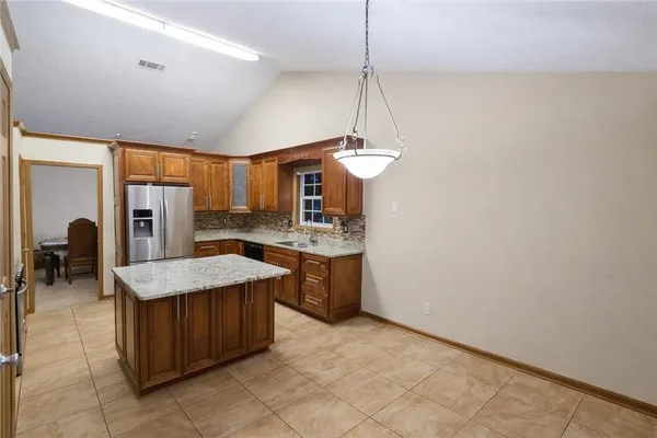 a kitchen with stainless steel appliances granite countertop a sink refrigerator and cabinets