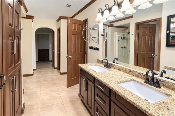 a bathroom with a granite countertop double vanity sink and a mirror