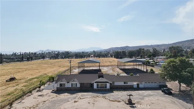 an aerial view of a house with a yard lake and mountain view in back