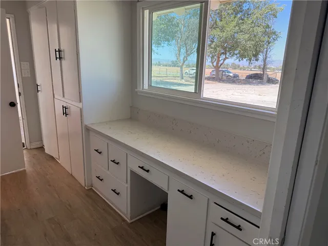 an entryway with wooden floor and cabinet