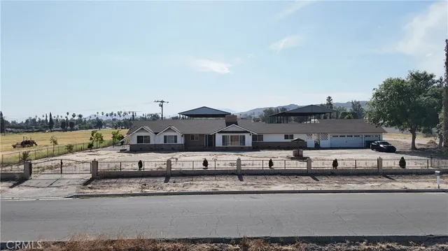 a view of a big house with a big yard and large trees
