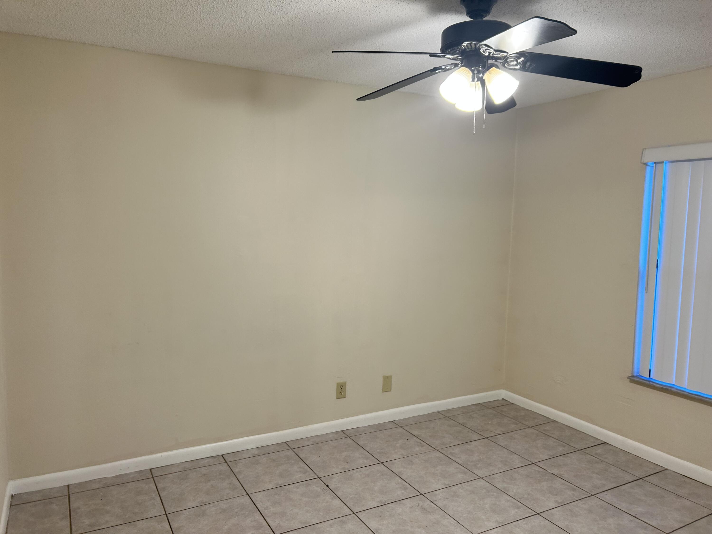 23 Crossings Circle, Unit E Boynton Beach, FL 33435 - Photo 4 of 19 an empty room with a window and a fan