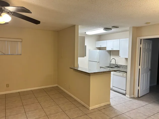 a kitchen with a sink a refrigerator and cabinets