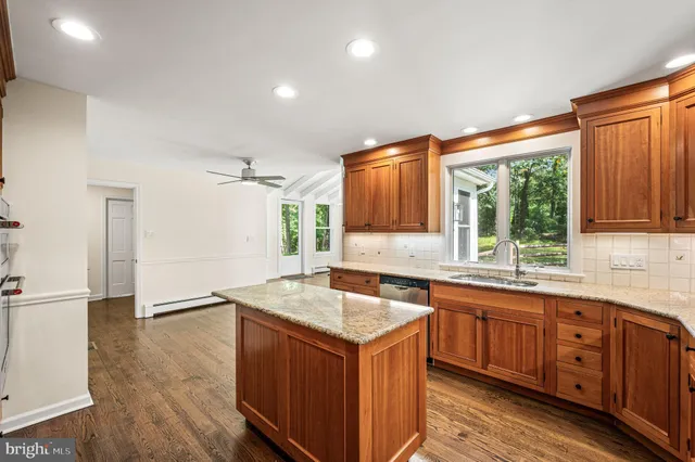 a kitchen with granite countertop cabinets sink and window