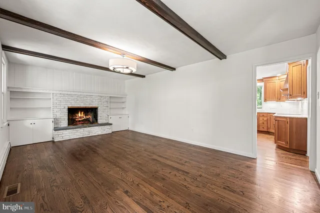 a living room with a fireplace and wooden floor
