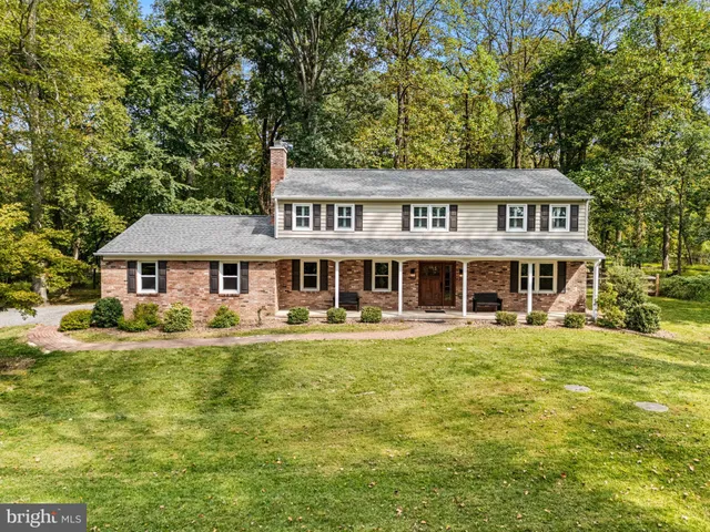 a aerial view of a house with a big yard and large trees
