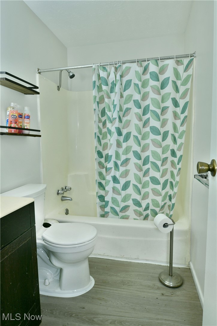 234 Howland Wilson Road Northeast Warren, OH 44484 - Photo 22 of 37 Bathroom featuring shower / tub combo with curtain, wood finished floors, and vanity