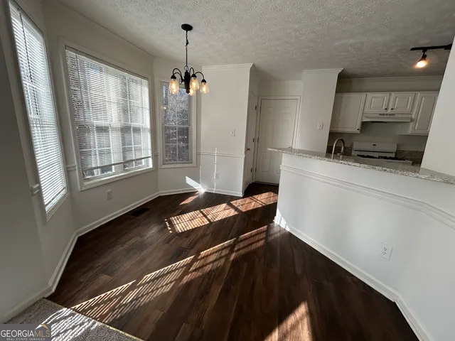 a kitchen with granite countertop a sink a stove and cabinets