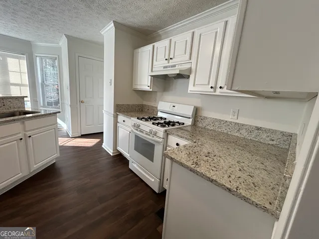 an empty room with windows fireplace and hardwood floor