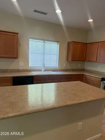a kitchen with a sink a stove top oven and white cabinets