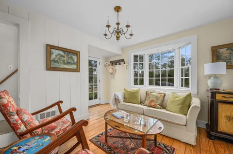 a living room with furniture a chandelier and a window