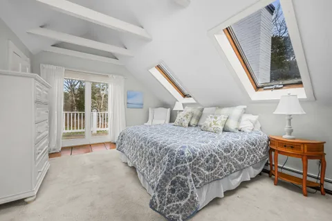 a bedroom with a bed a mirror and a window