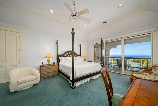 a bedroom with a bed a couch and a chandelier