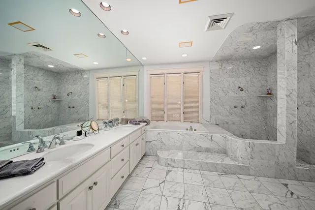 a spacious bathroom with a double vanity sink mirror and shower