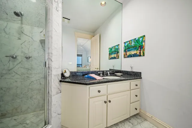 a bathroom with a granite countertop sink and a mirror