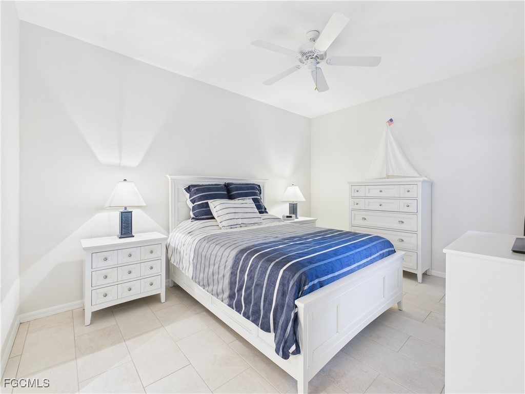 10461 Washingtonia Palm Way, Unit 3436 Fort Myers, FL 33966 - Photo 11 of 32 a bedroom with a bed and a chandelier