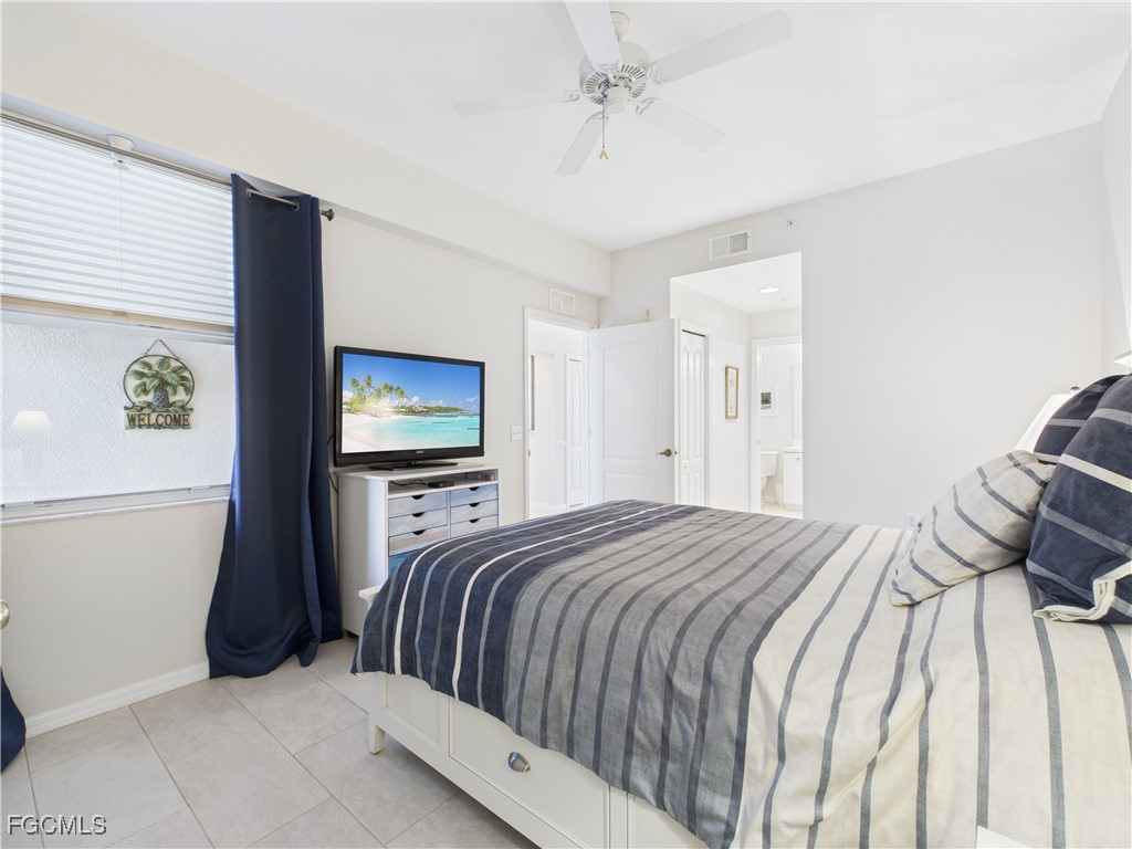 10461 Washingtonia Palm Way, Unit 3436 Fort Myers, FL 33966 - Photo 12 of 32 a bedroom with a bed and a flat screen tv