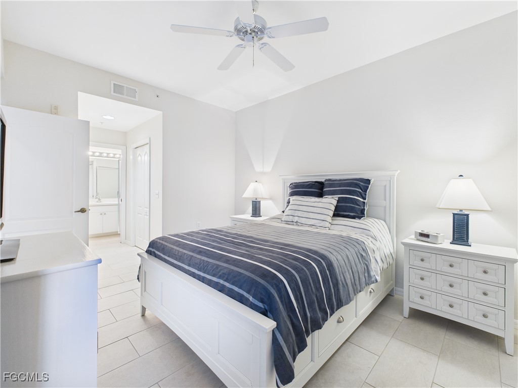 10461 Washingtonia Palm Way, Unit 3436 Fort Myers, FL 33966 - Photo 13 of 32 a bedroom with a bed and a chandelier