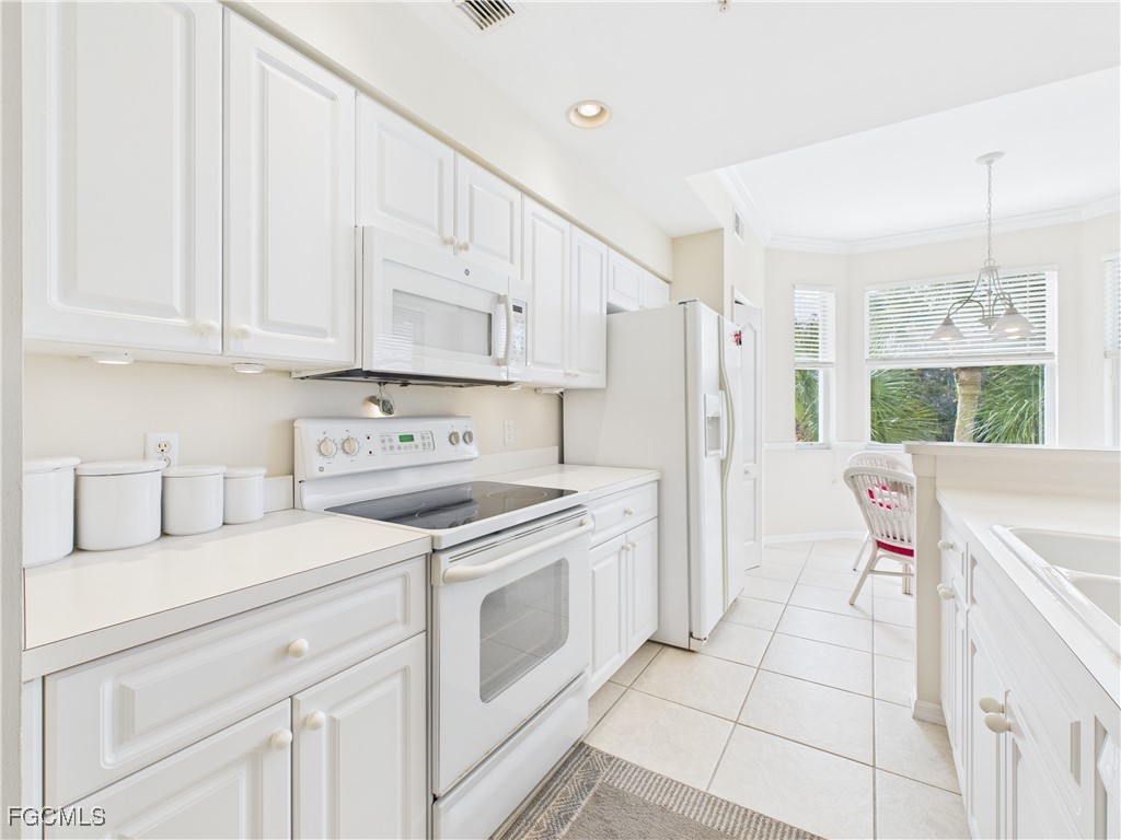 10461 Washingtonia Palm Way, Unit 3436 Fort Myers, FL 33966 - Photo 5 of 32 a kitchen with stainless steel appliances white cabinets and a window