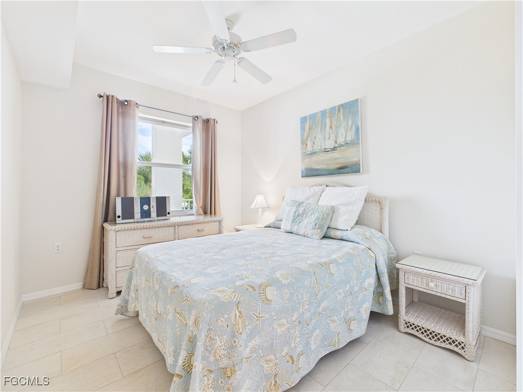 10461 Washingtonia Palm Way, Unit 3436 Fort Myers, FL 33966 - Photo 7 of 32 a bedroom with a bed and a chandelier