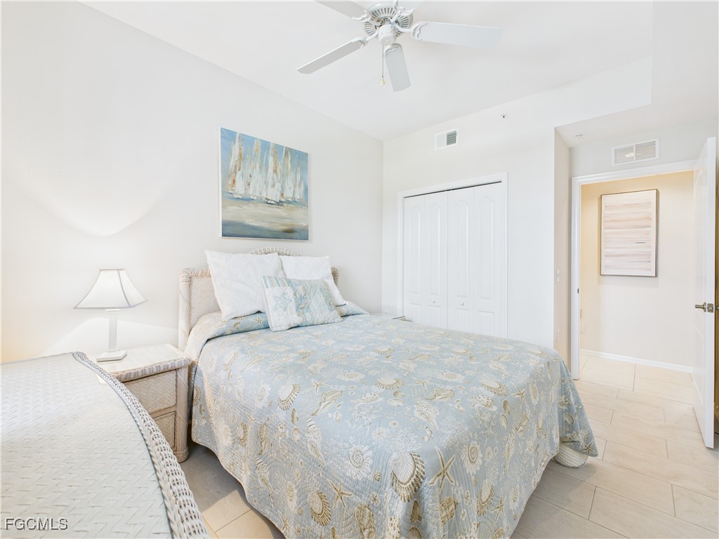 10461 Washingtonia Palm Way, Unit 3436 Fort Myers, FL 33966 - Photo 8 of 32 a bedroom with a bed and a chandelier