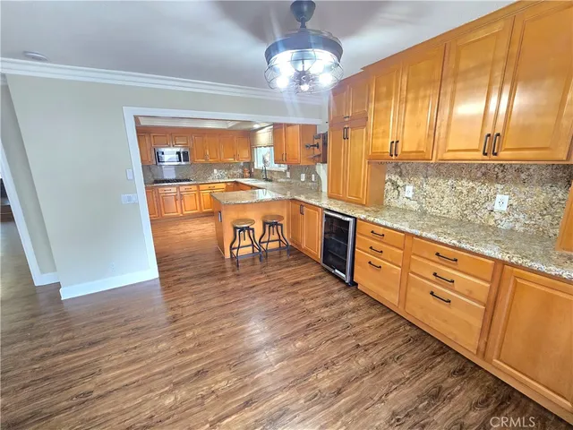 a large kitchen with stainless steel appliances granite countertop a sink dishwasher a stove with wooden floor